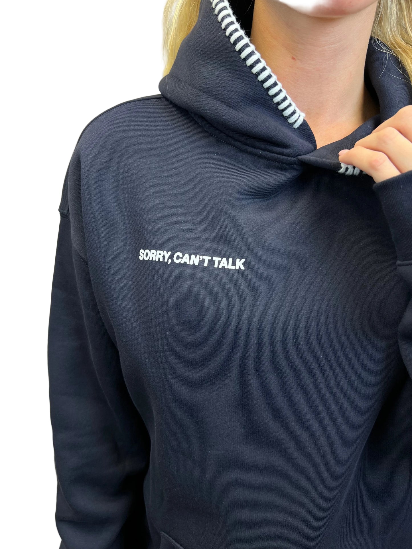 Navy blue hoodie with 'SORRY, CAN'T TALK' text on a neutral background